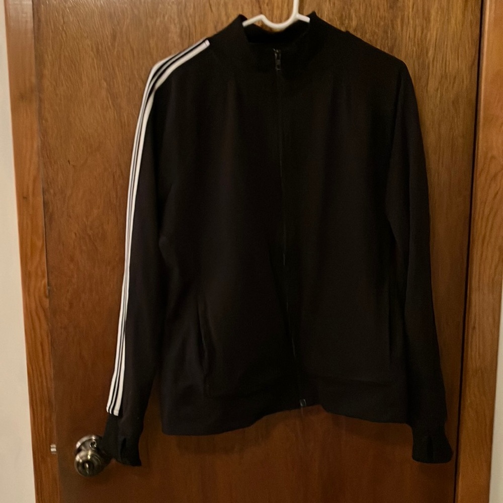 Zip up jacket, black with white stripes down both arms, with Pockets.